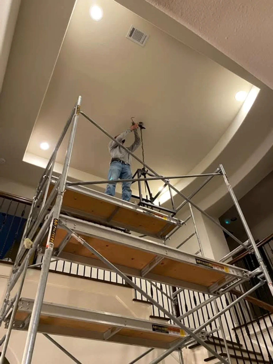 High ceiling chandelier installation in progress